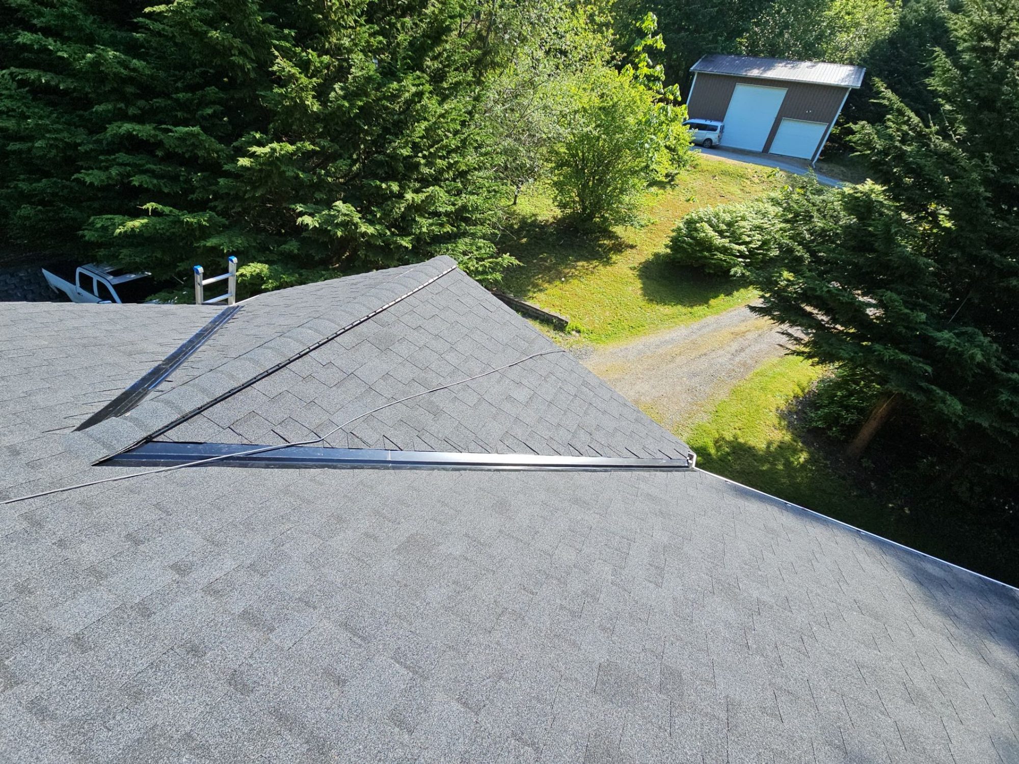 New skylight set into the Antique Black asphalt shingle roof above the lawn, Tulalip Bay, WA