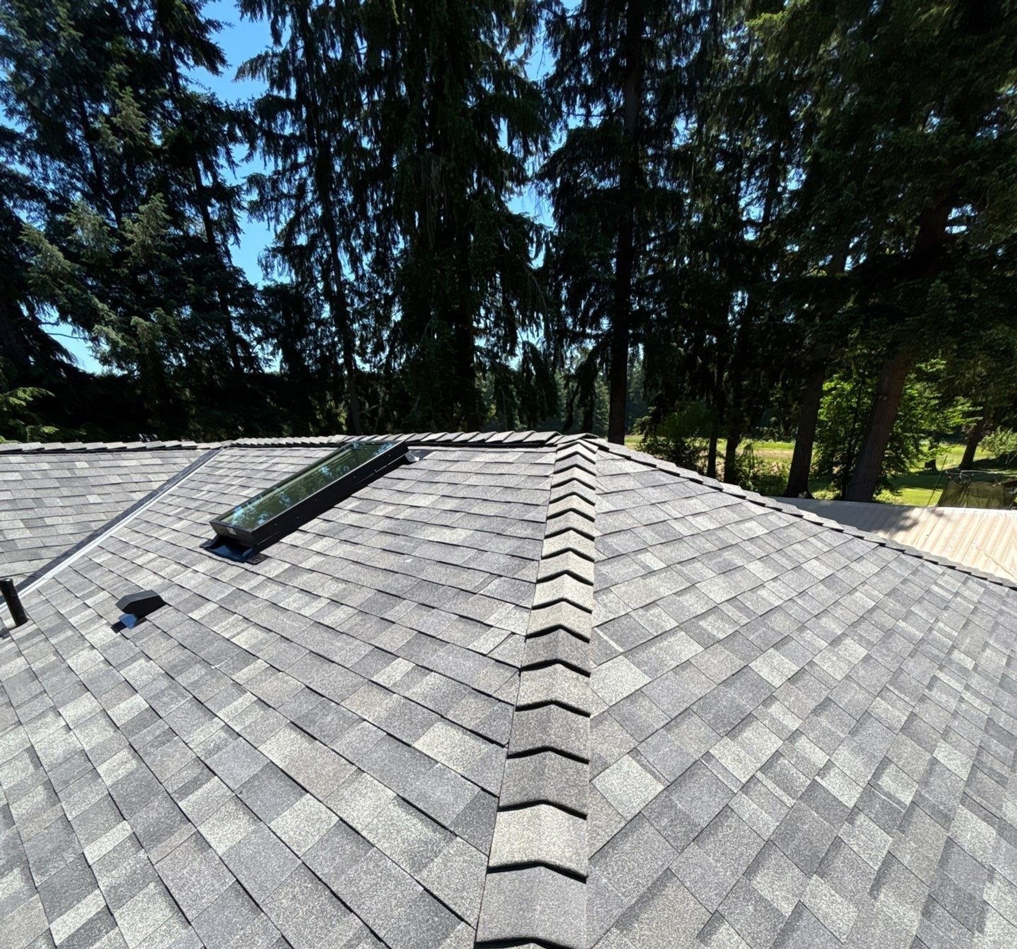 Ridge of the Malarkey Storm Grey asphalt shingle roof looking toward the trees, Lake Stevens, WA