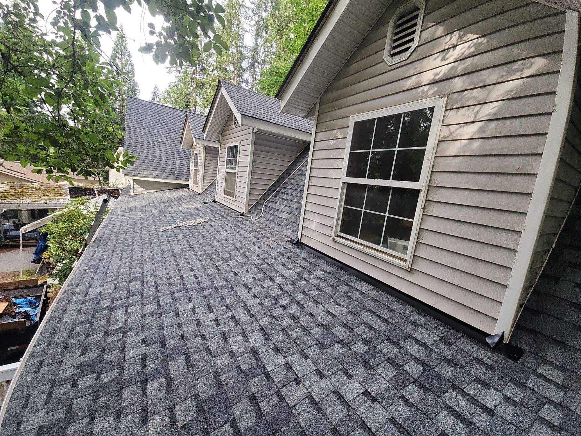 Finished Pabco Premier Pewter Gray asphalt shingle roof running past both dormers into the forest, Lake Stevens, WA, by Amor Roofing