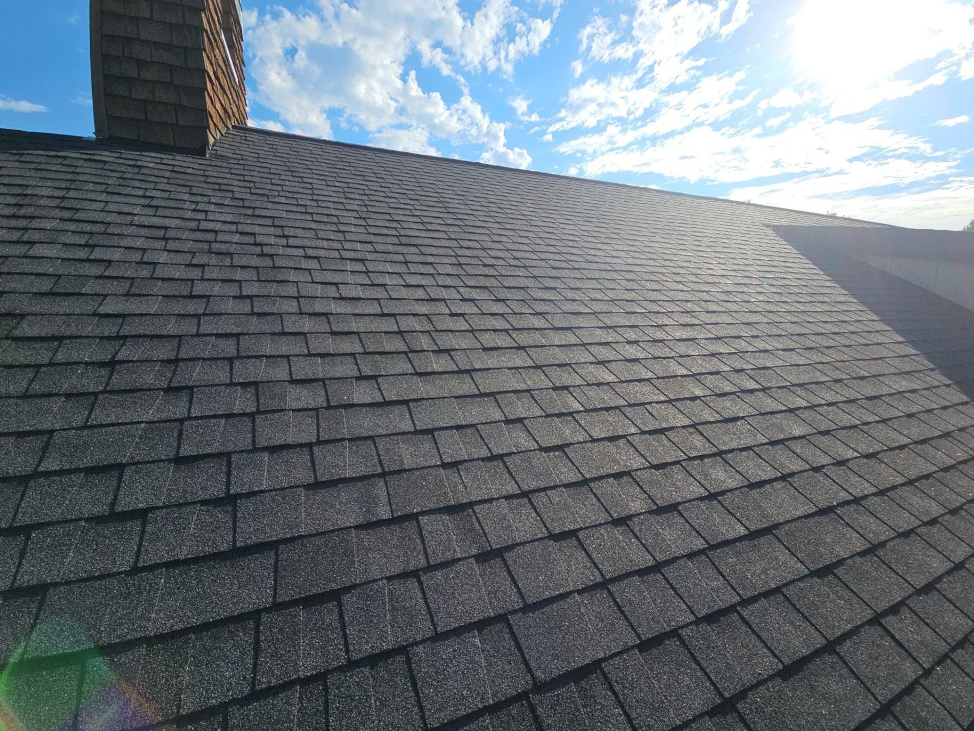 Finished Antique Black asphalt shingle roof ridge into the afternoon sun, Woodinville, WA