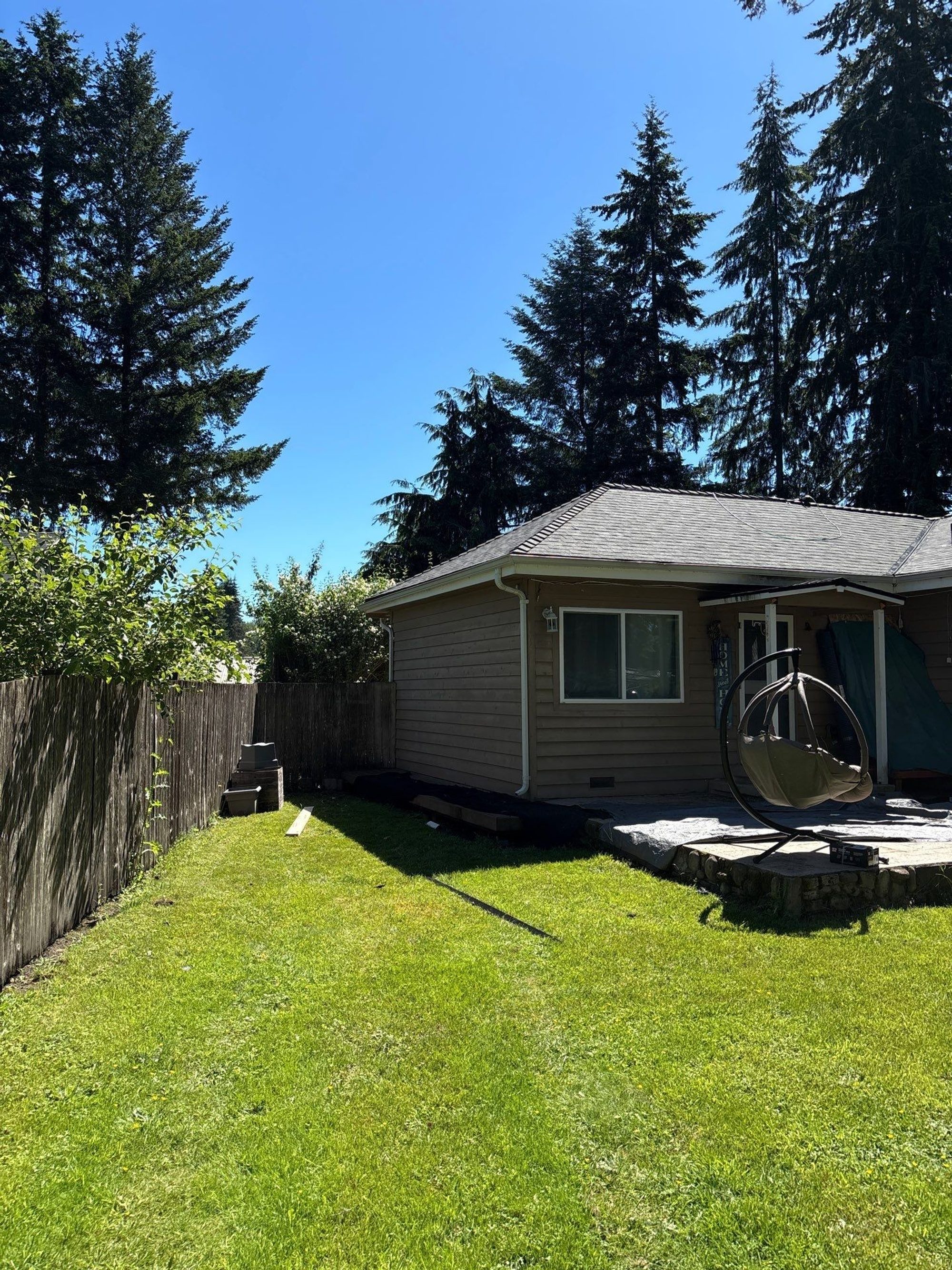 Back-yard view of the finished Malarkey Storm Grey asphalt shingle roof under blue sky, Lake Stevens, WA