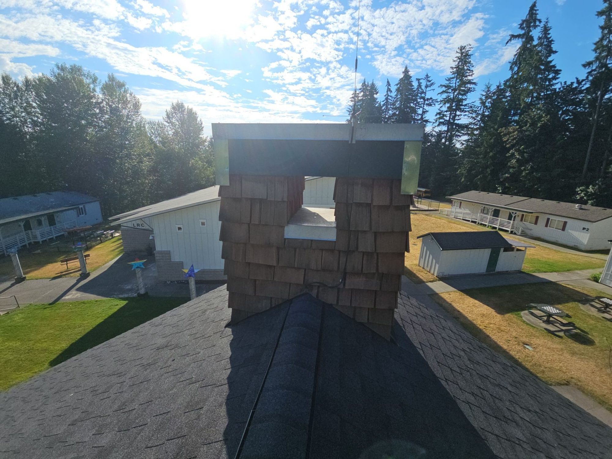 Cedar-clad chimney detail on the finished Antique Black asphalt shingle roof, Woodinville, WA