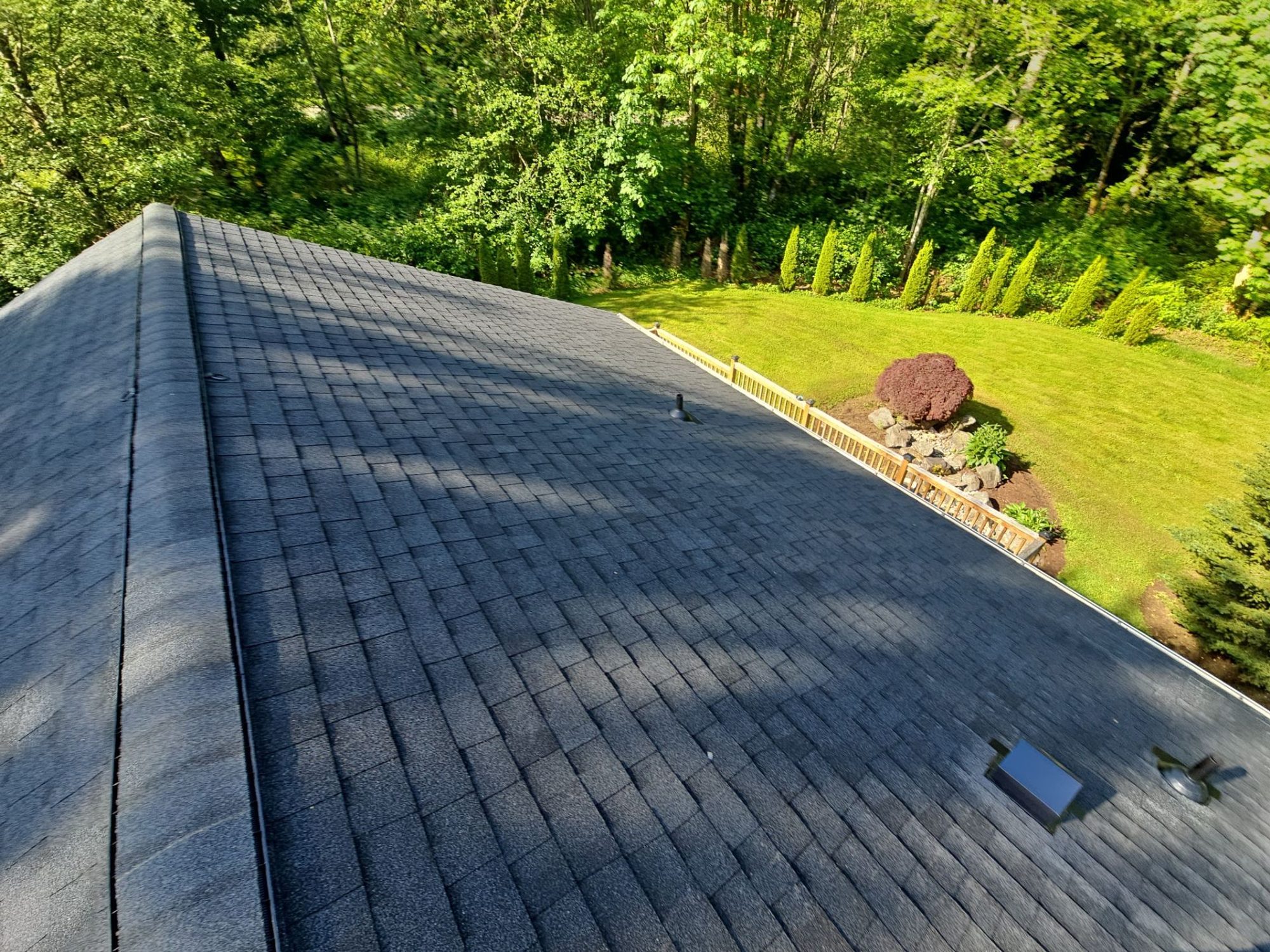 Finished Antique Black asphalt shingle roof with a new skylight above the garden and forest, Tulalip Bay, WA, by Amor Roofing