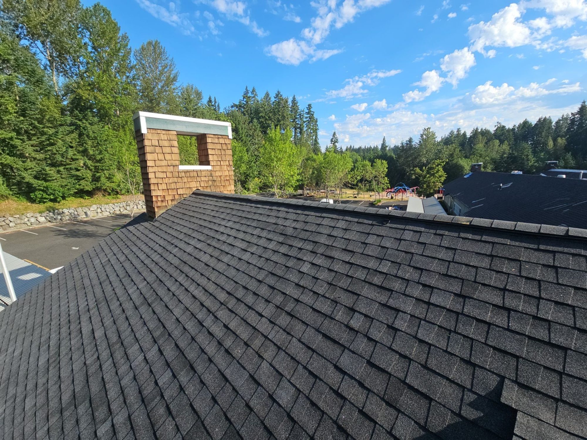Brick and cedar chimney on the finished Antique Black asphalt shingle roof, Building A, Woodinville, WA