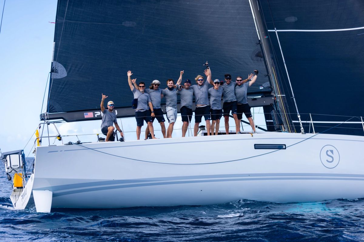 Pimu crew waving from the deck after finishing in Grenada
