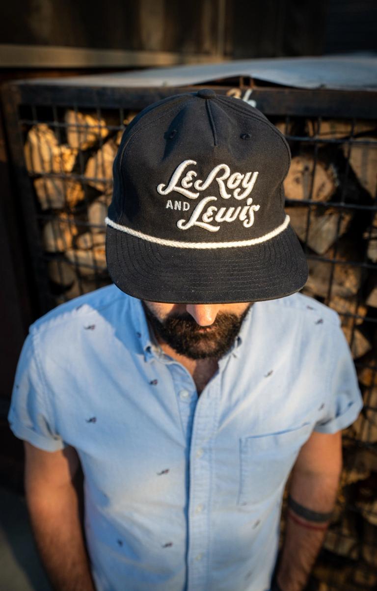 Black rope cap with the LeRoy and Lewis script in white
