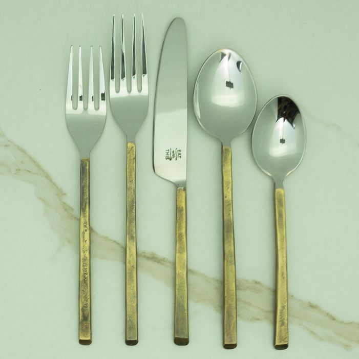 Brass flatware flatlay on a sage place setting
