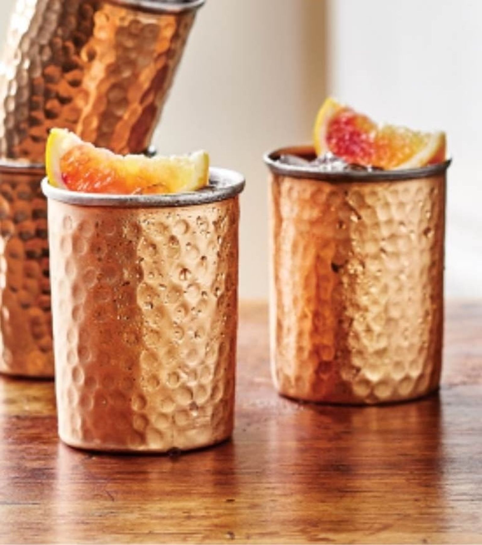 Hammered copper tumblers served with grapefruit