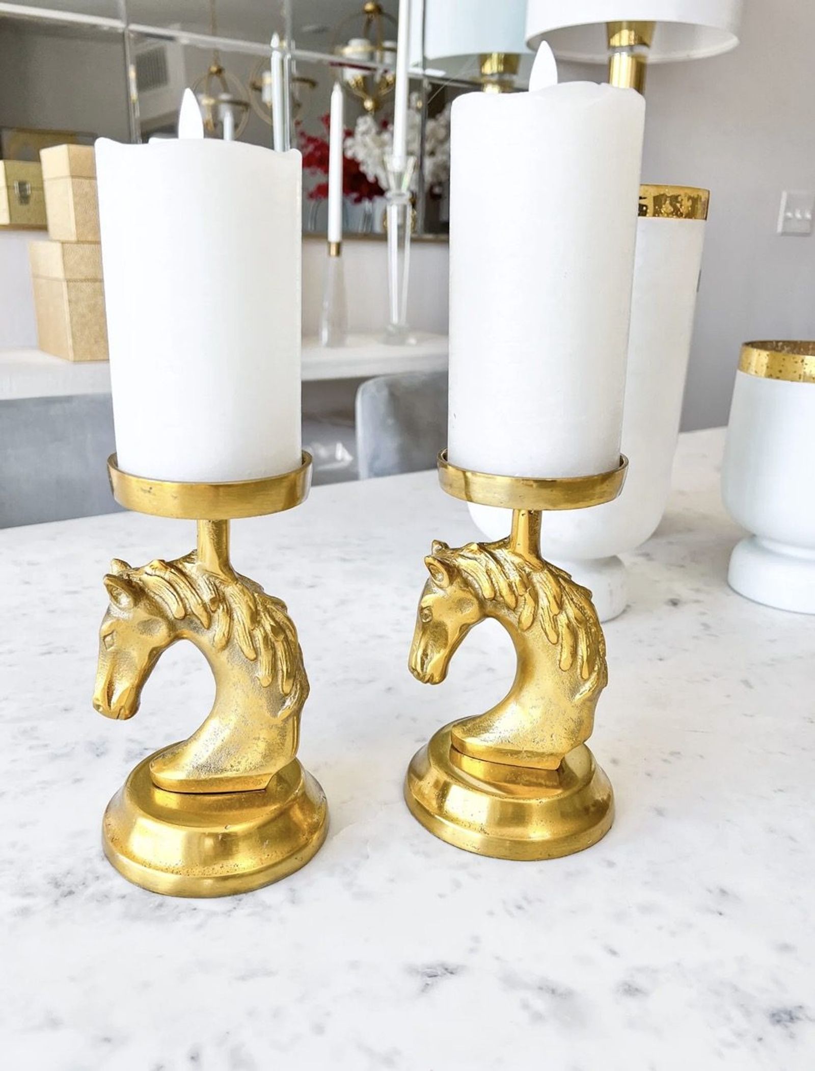 Brass horse-head candlesticks on a marble counter