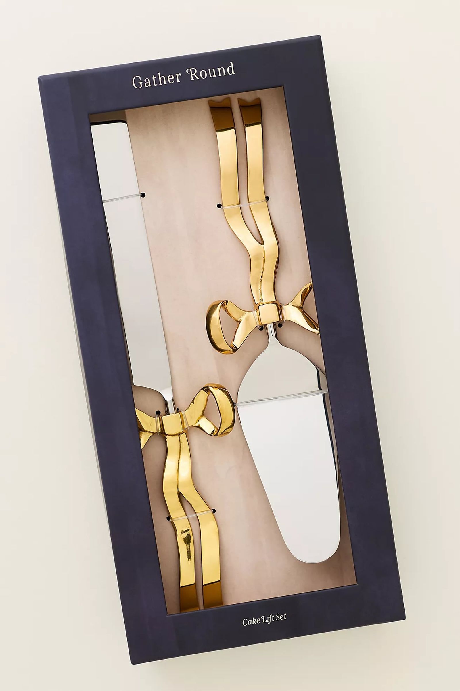 Boxed gift set of gold cake servers with bow handles