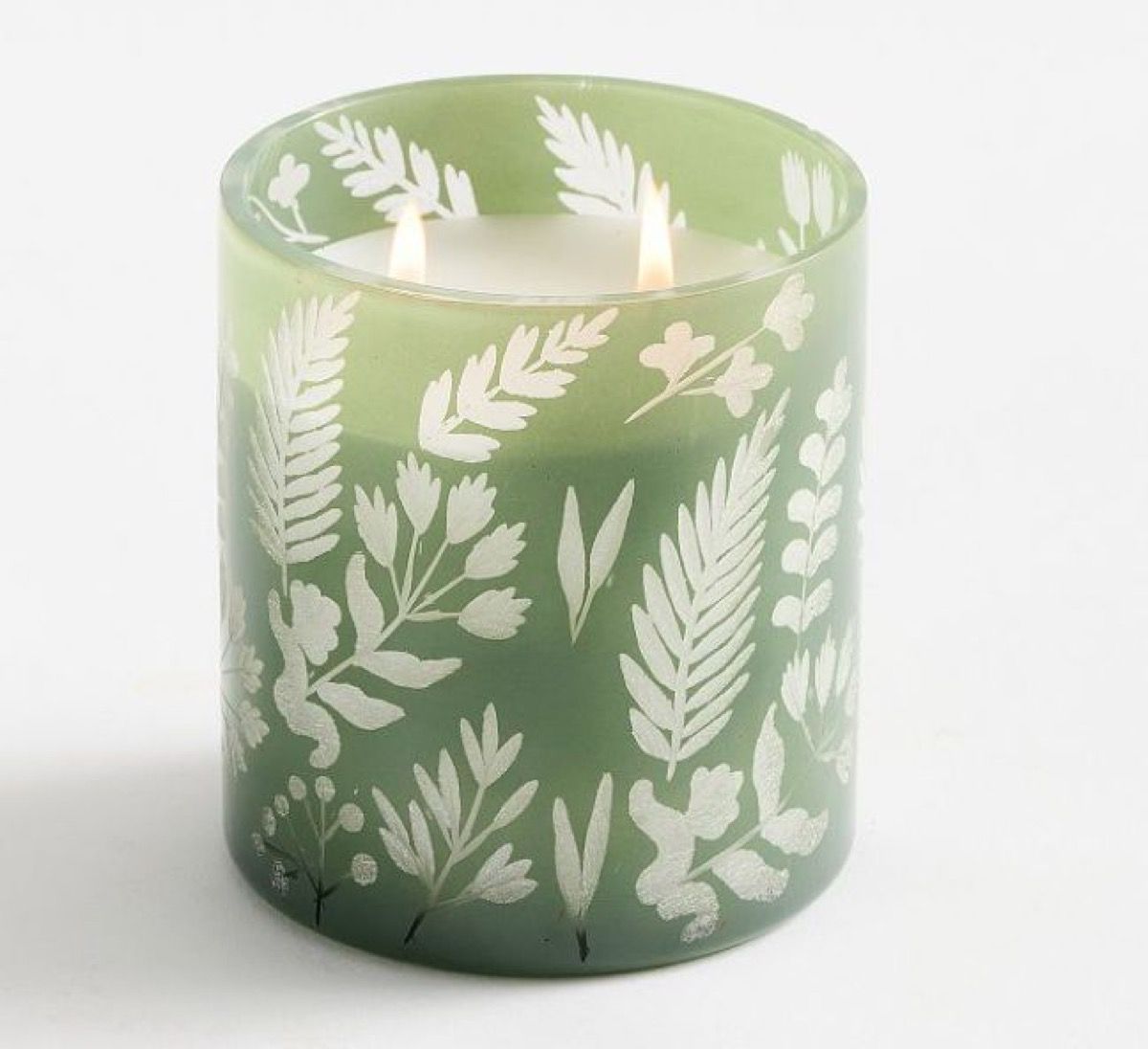Green glass candle vessel with an etched white botanical pattern