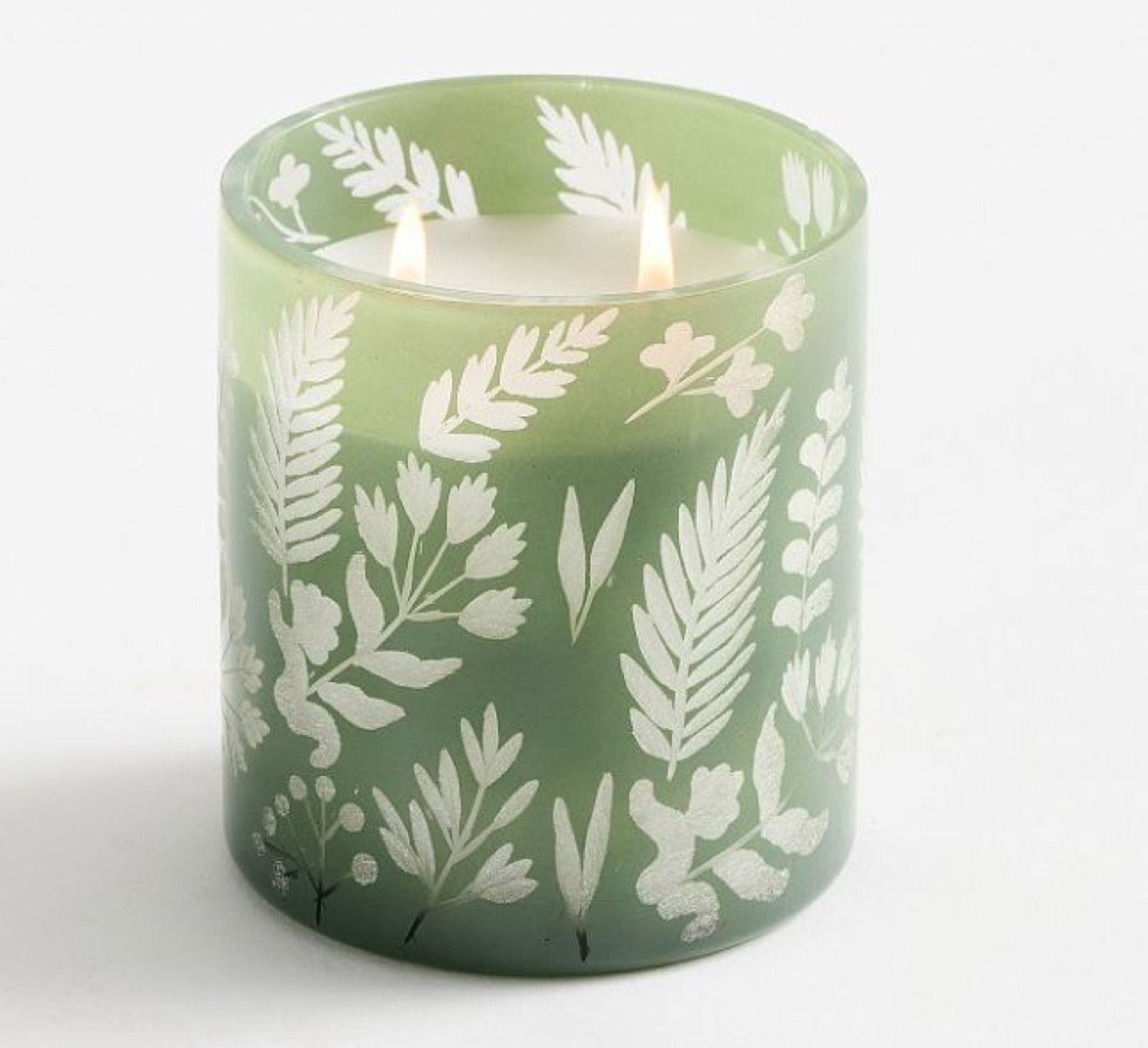 Green glass candle vessel with an etched white botanical pattern