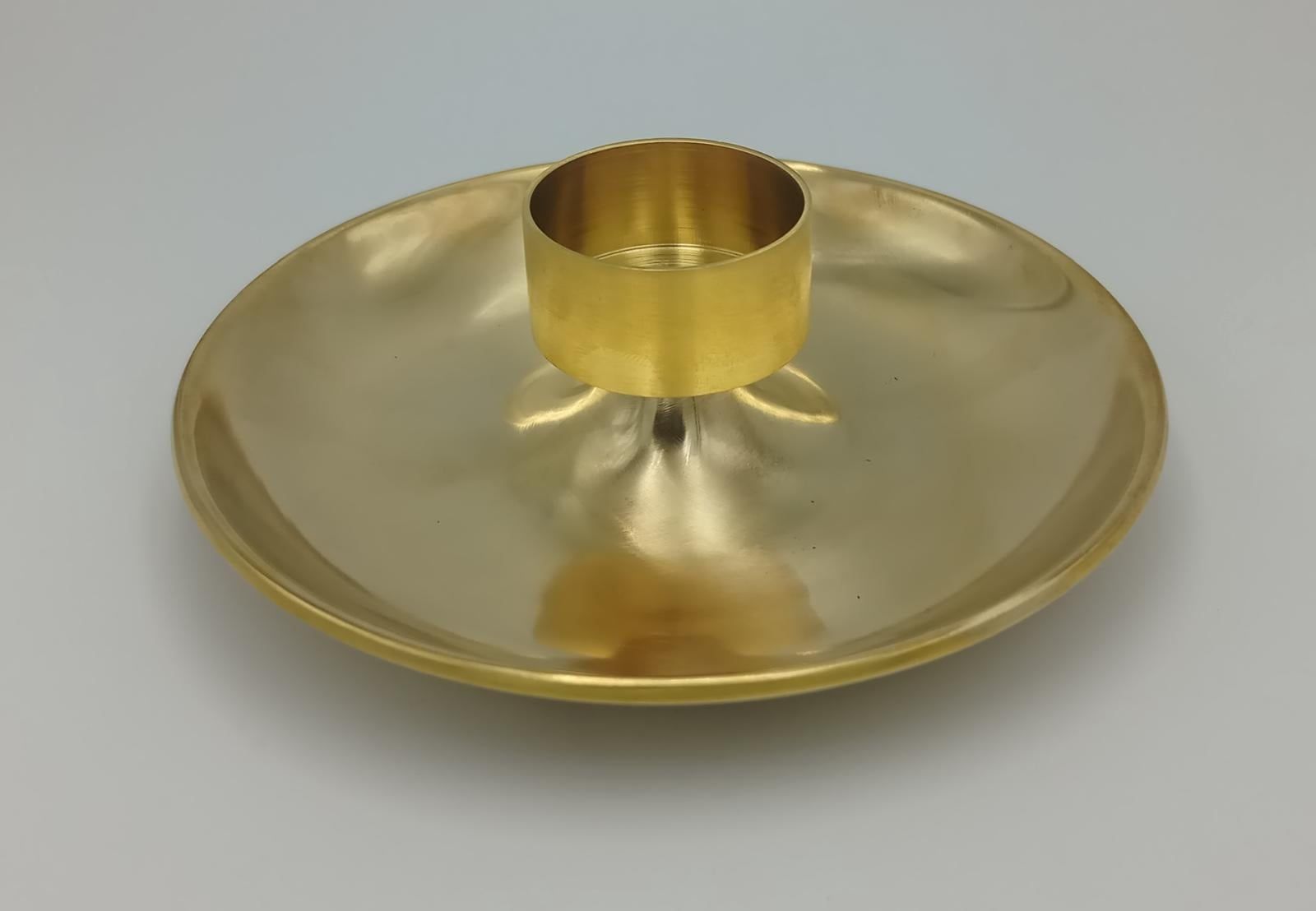 Turned brass candle holder with a wide disc base
