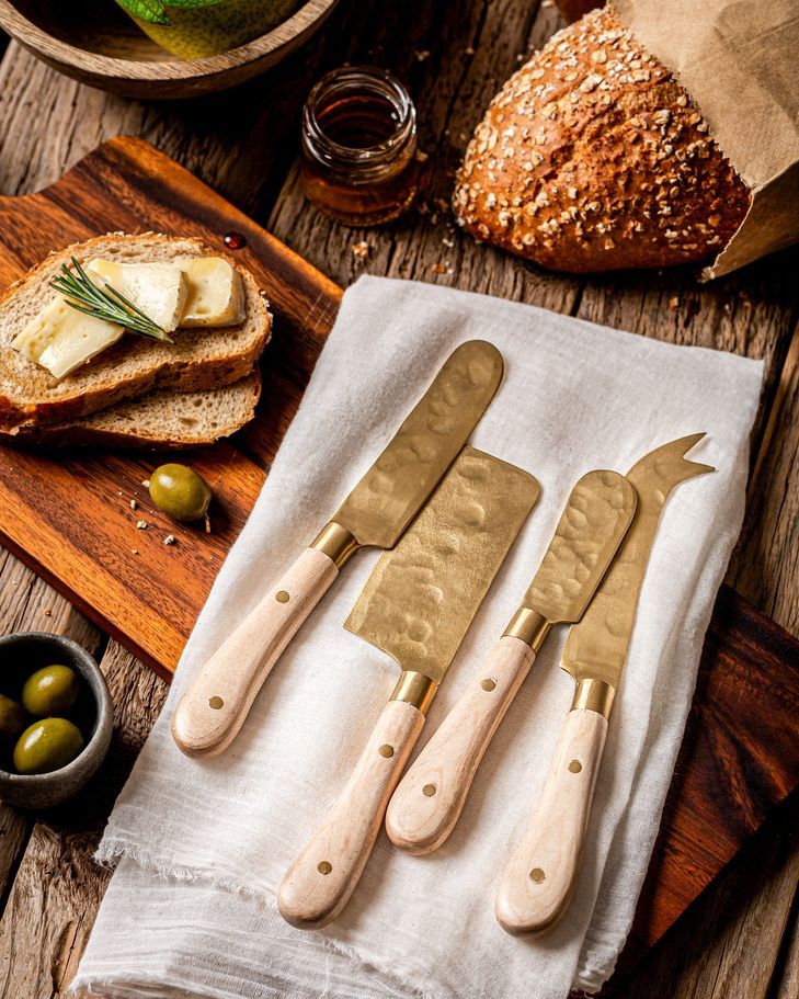 Cheese knife set with bread and olives on linen