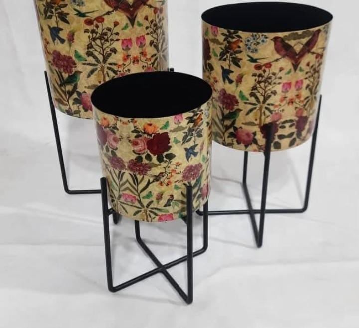 Botanical-printed metal planters on black stands