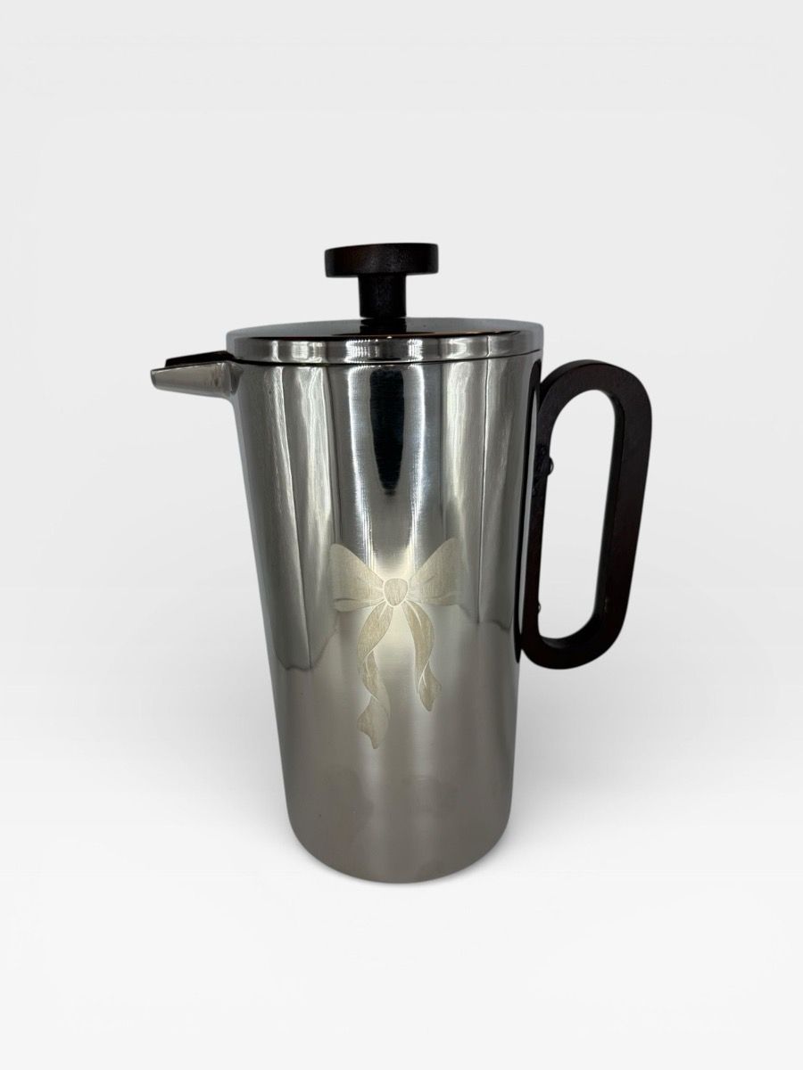 Polished double-wall stainless French press with etched bow motif and wood handle