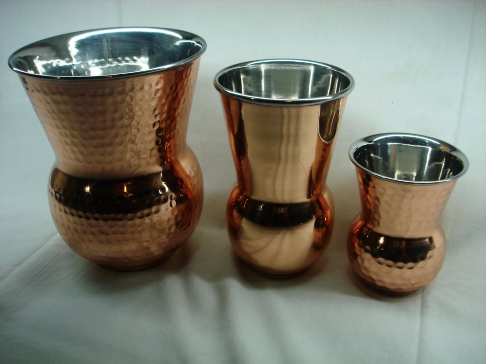 Hammered copper vessels in graduated sizes