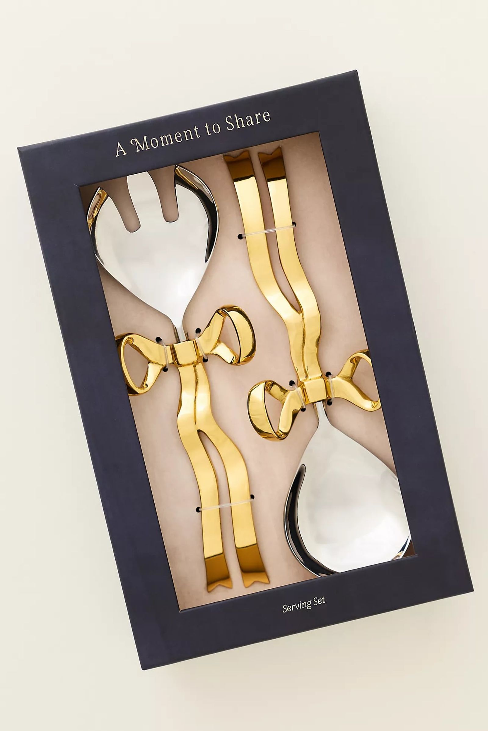 Boxed gift set of gold serving pieces with bow handles