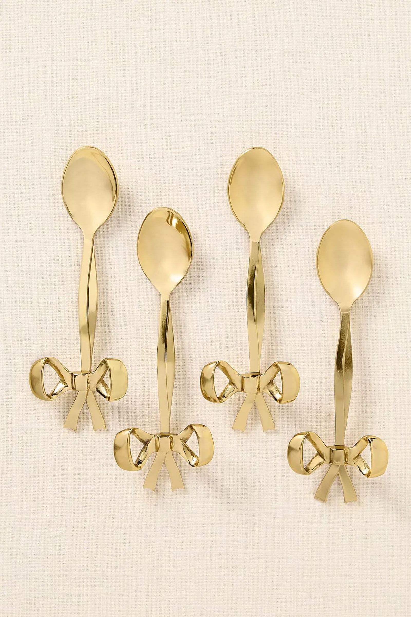 Gold bow-handle dessert spoons, set of four