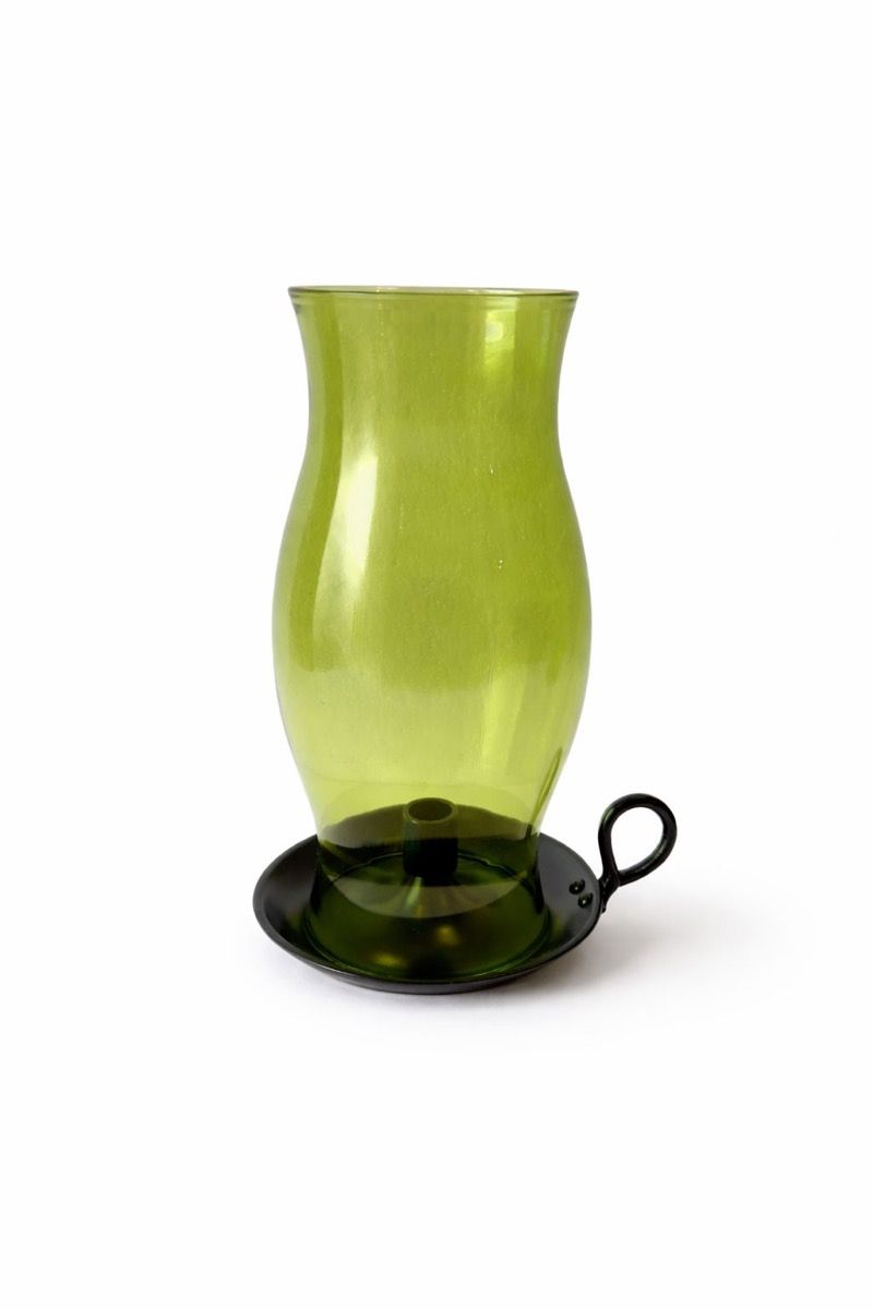 Green hand-blown glass hurricane on a candle plate with a loop handle