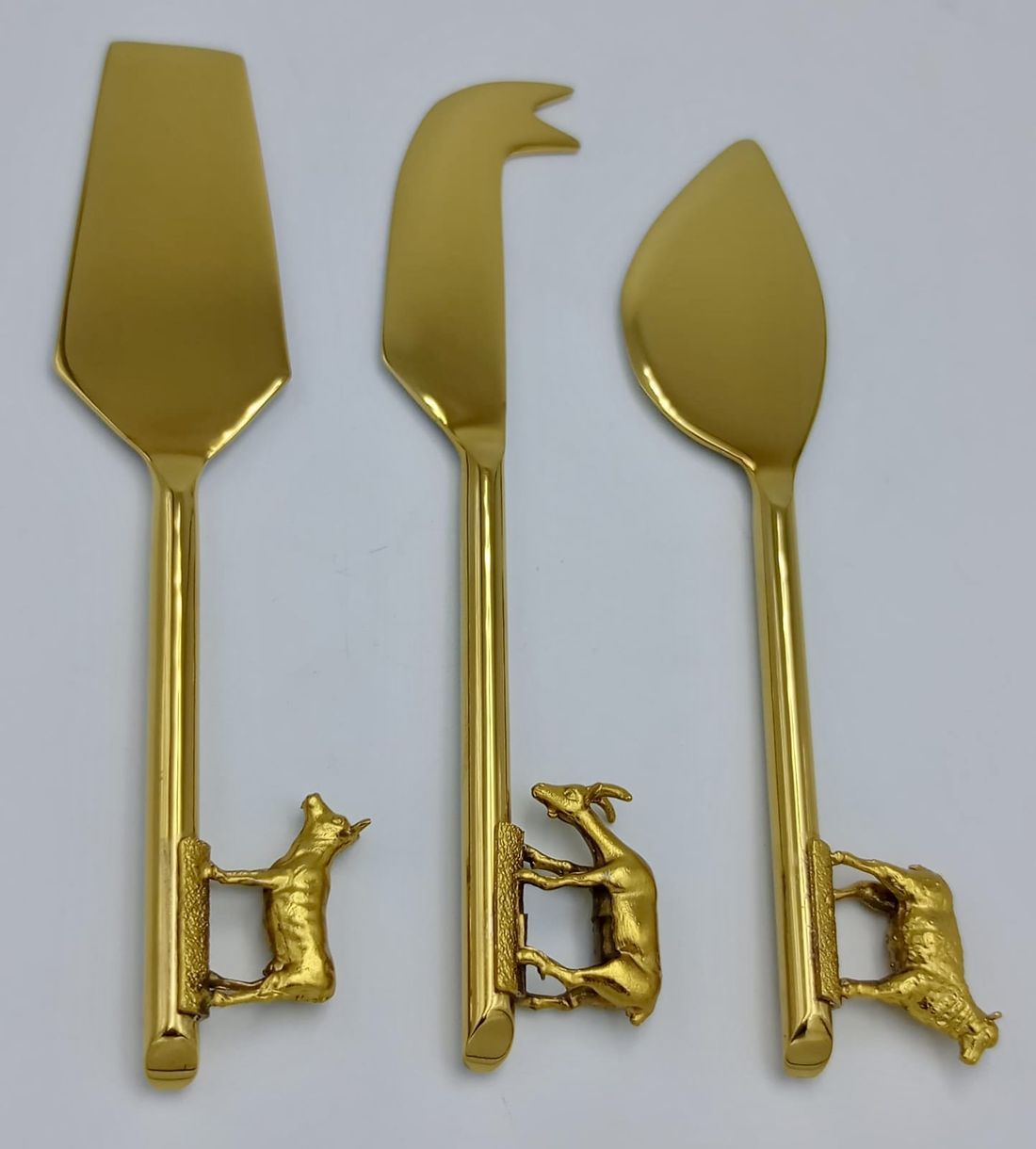 Gold cheese tools with sculpted animal handles