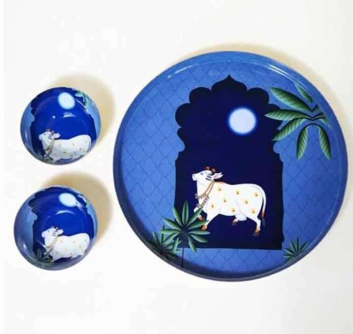 Blue hand-painted ceramic plates with a folk-art motif