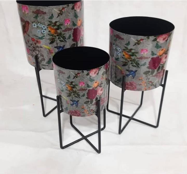Floral-printed metal planters on black stands