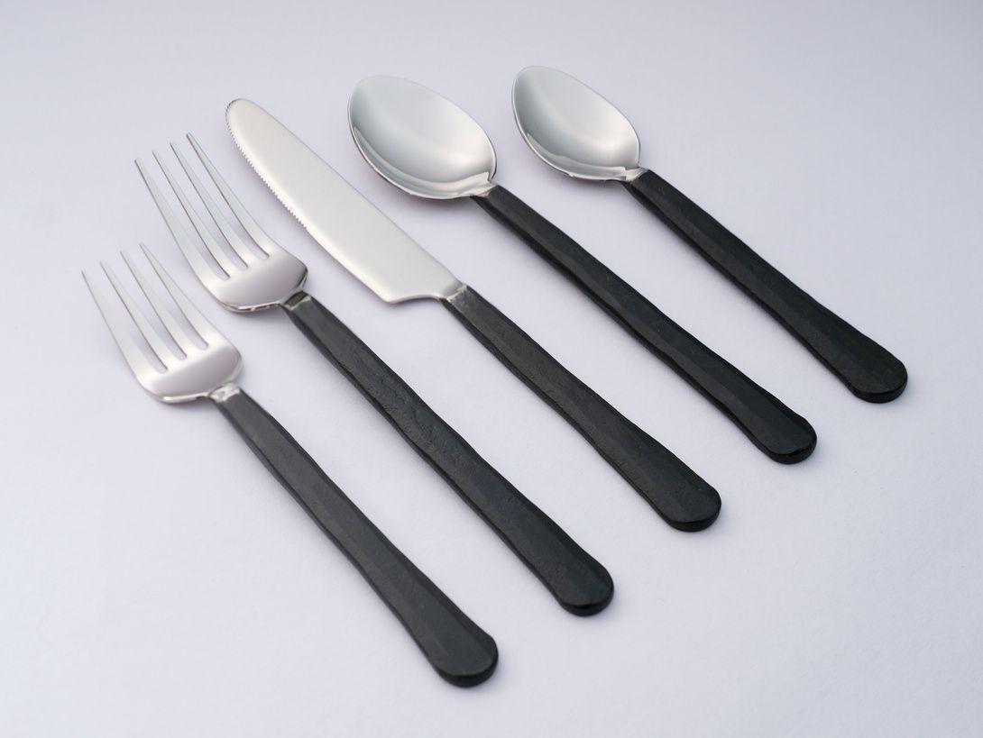 Mixed satin-steel and black flatware, top-down
