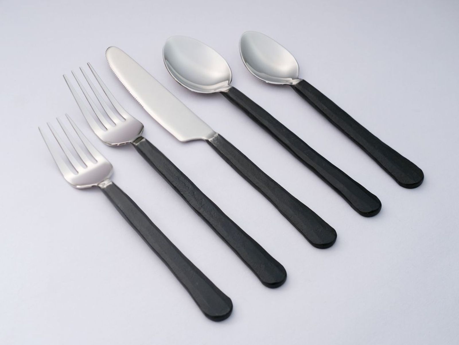 Mixed satin-steel and black flatware, top-down