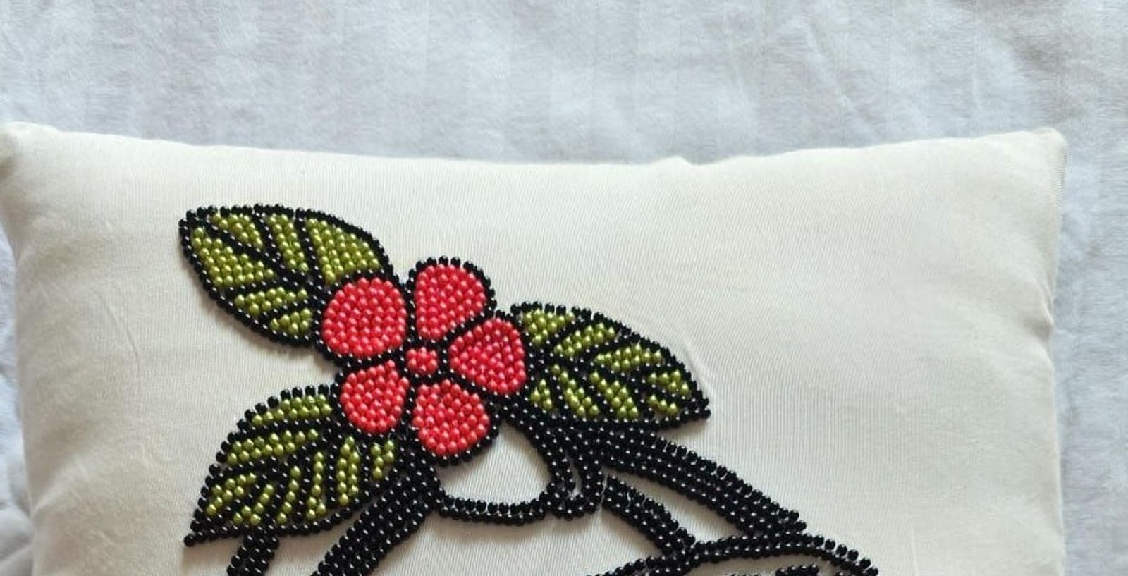 Hand-beaded floral cushion in red and green glass beads