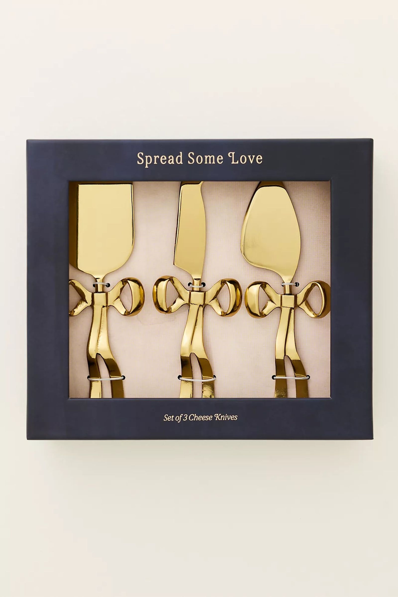 Boxed gift set of gold cheese knives with bow handles