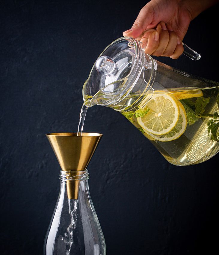 Brass funnel pouring fresh lemonade
