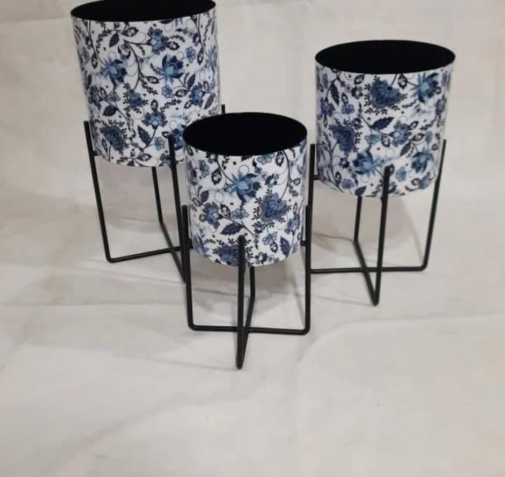 Blue floral-printed metal planters on black stands