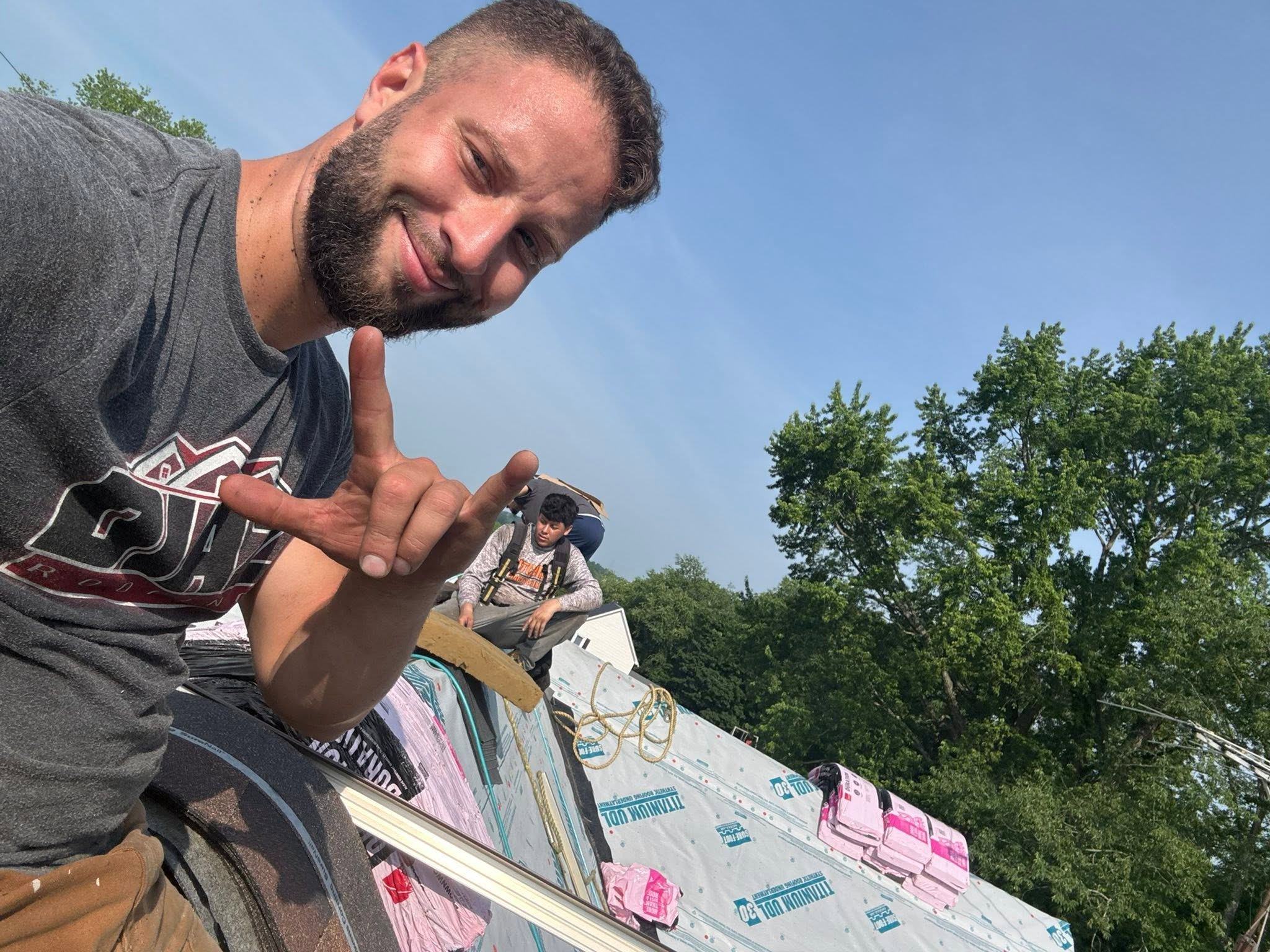 A Diaz Roofing roofer on a job, smiling for the camera