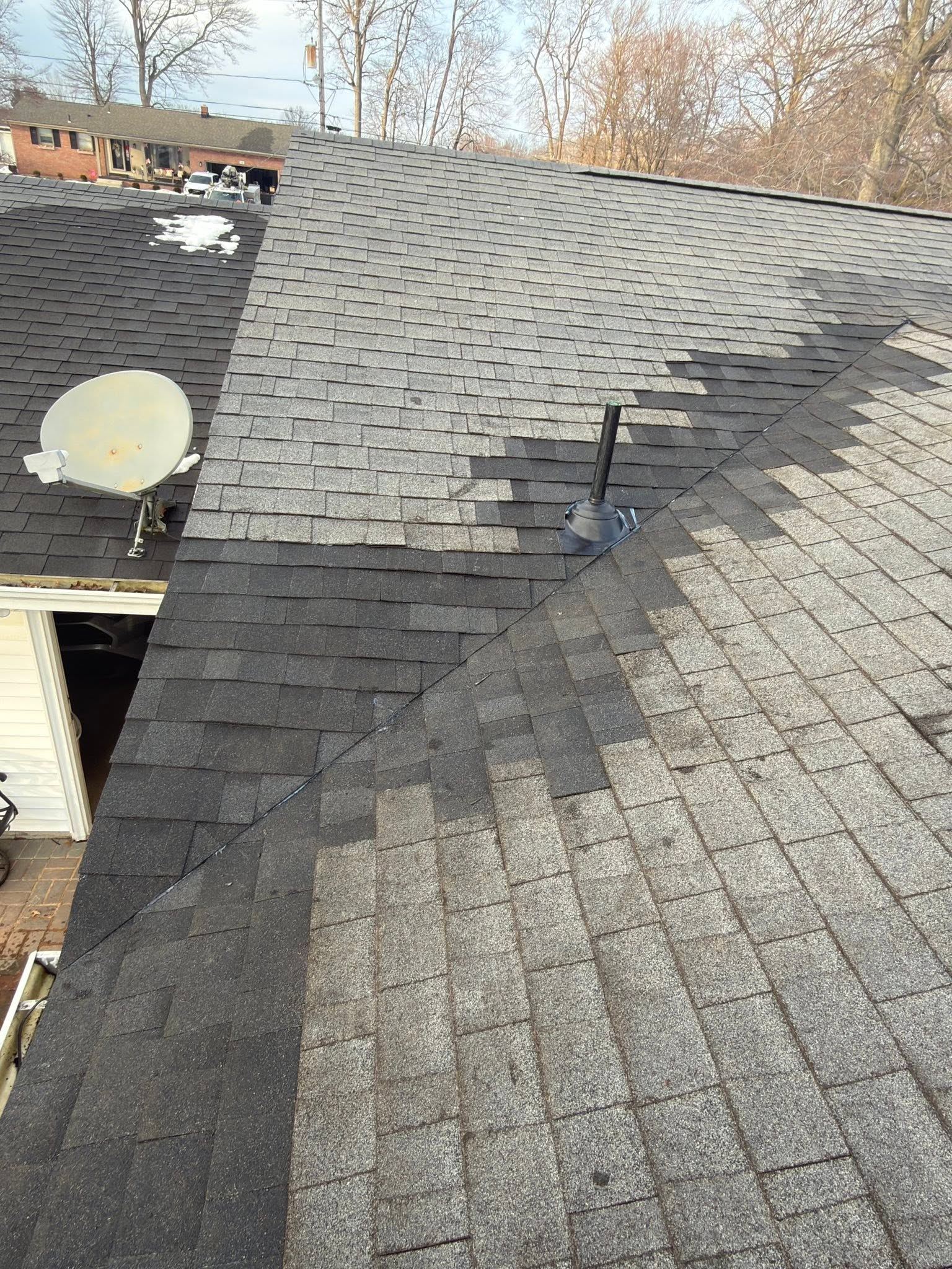 New shingles patched into an older roof around a vent pipe