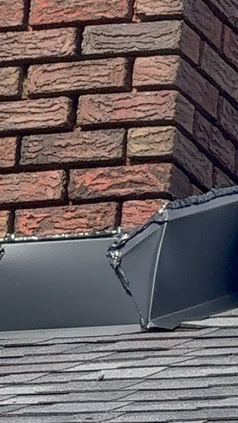 The corner of a chimney where the metal flashing meets the brick