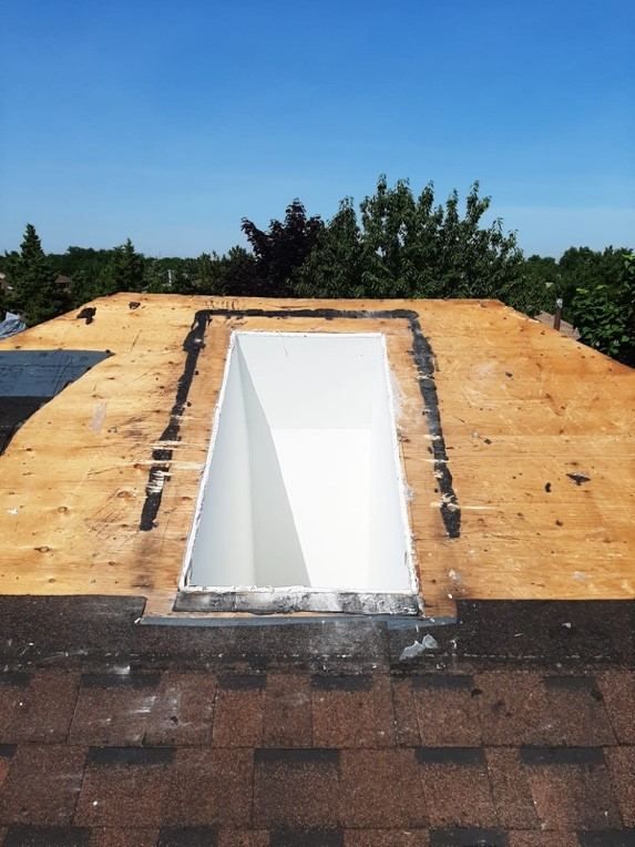 An opening framed in the roof deck for a skylight, its shaft lined in white