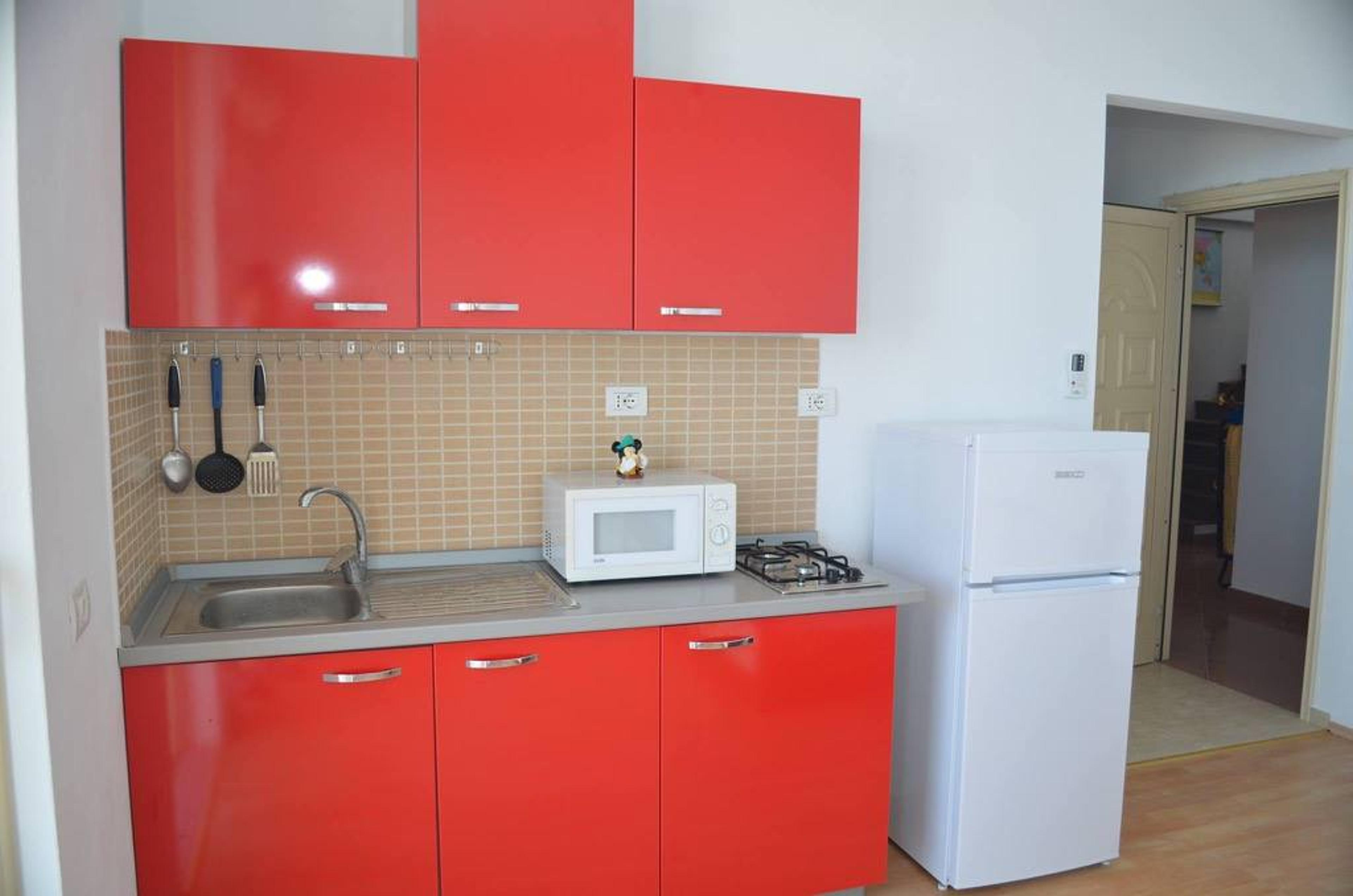 Red kitchen with fridge and microwave
