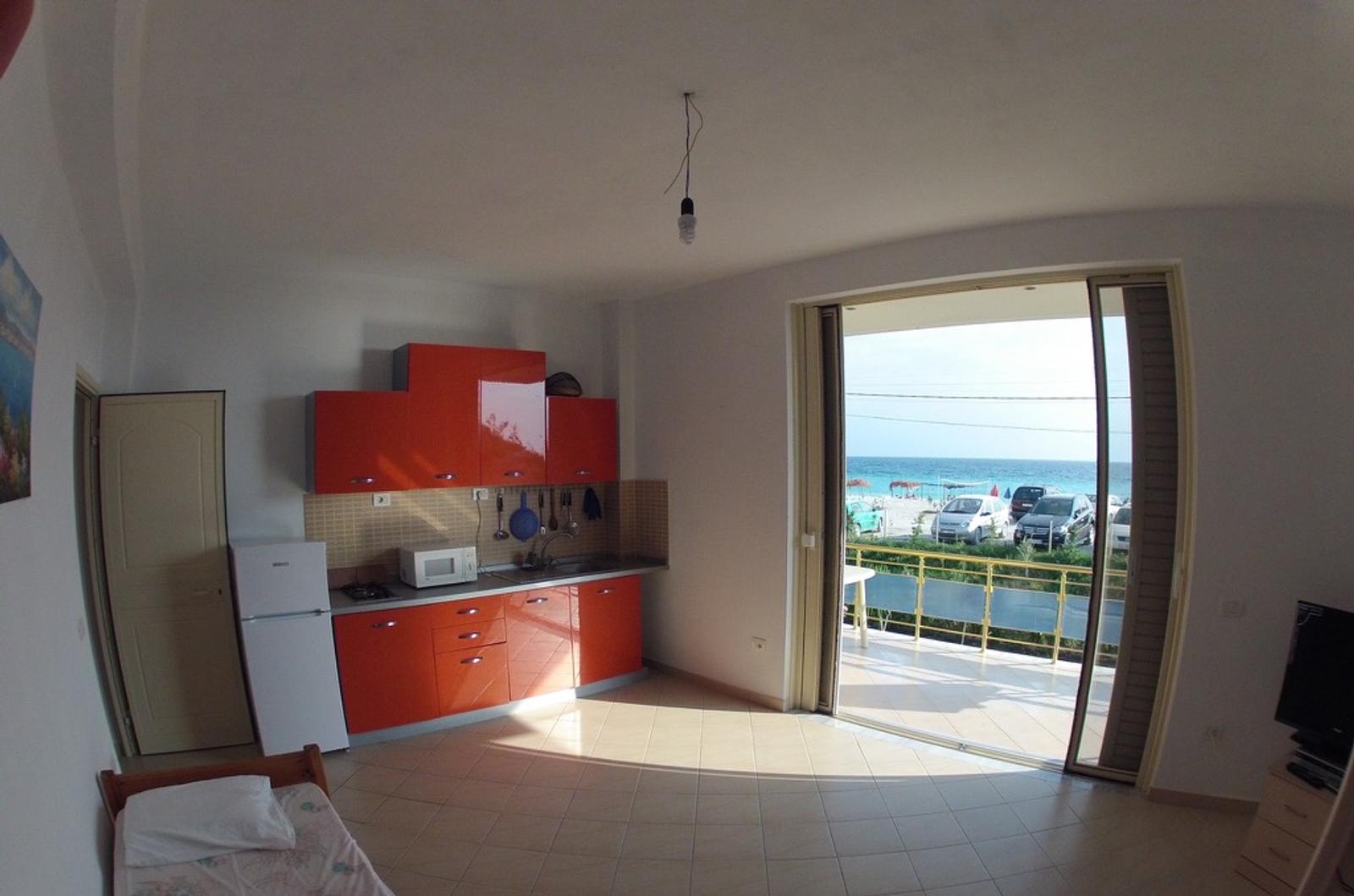 Living room with view of kitchen, single bed and balcony