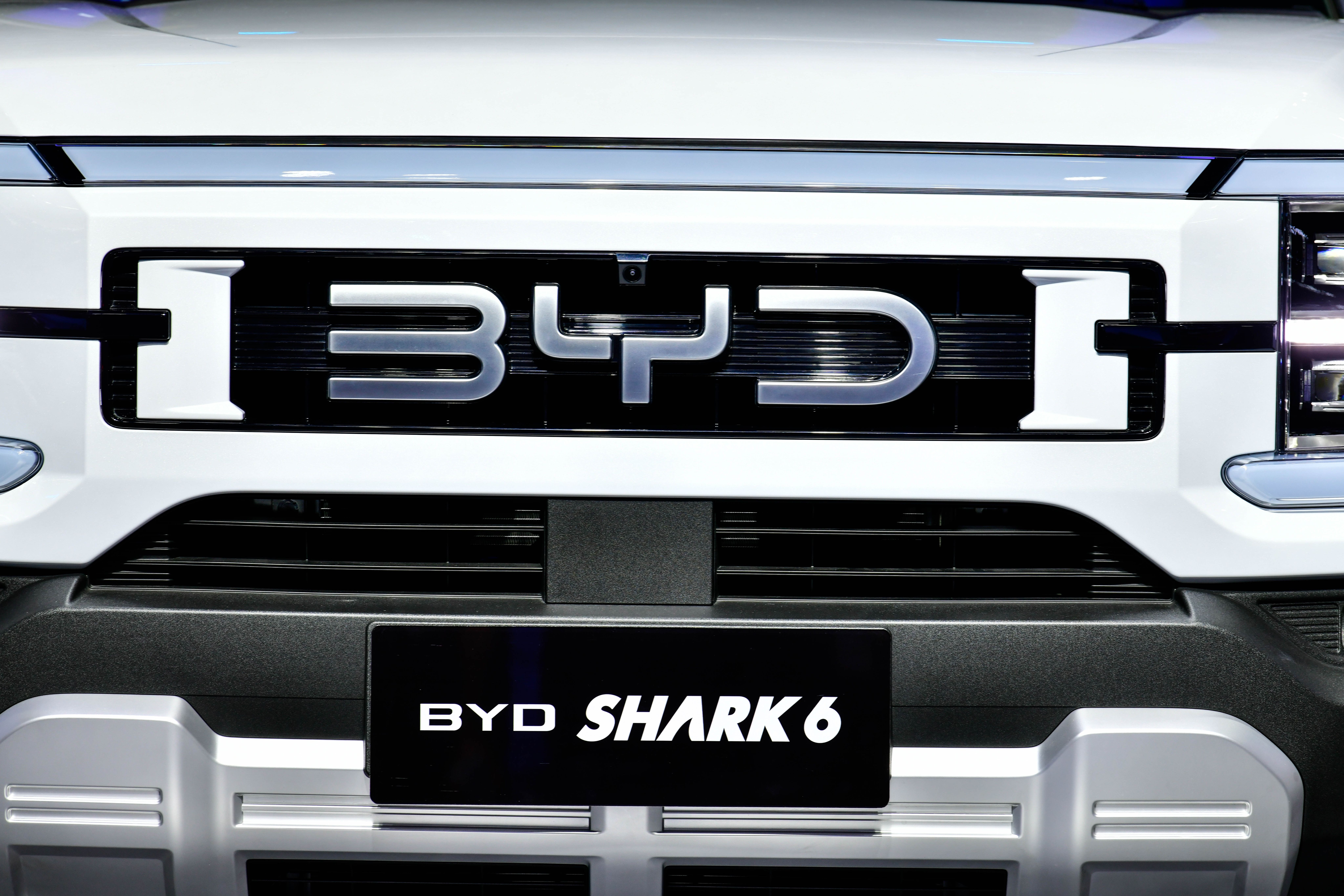 Close-up of the grille of a white BYD Shark 6