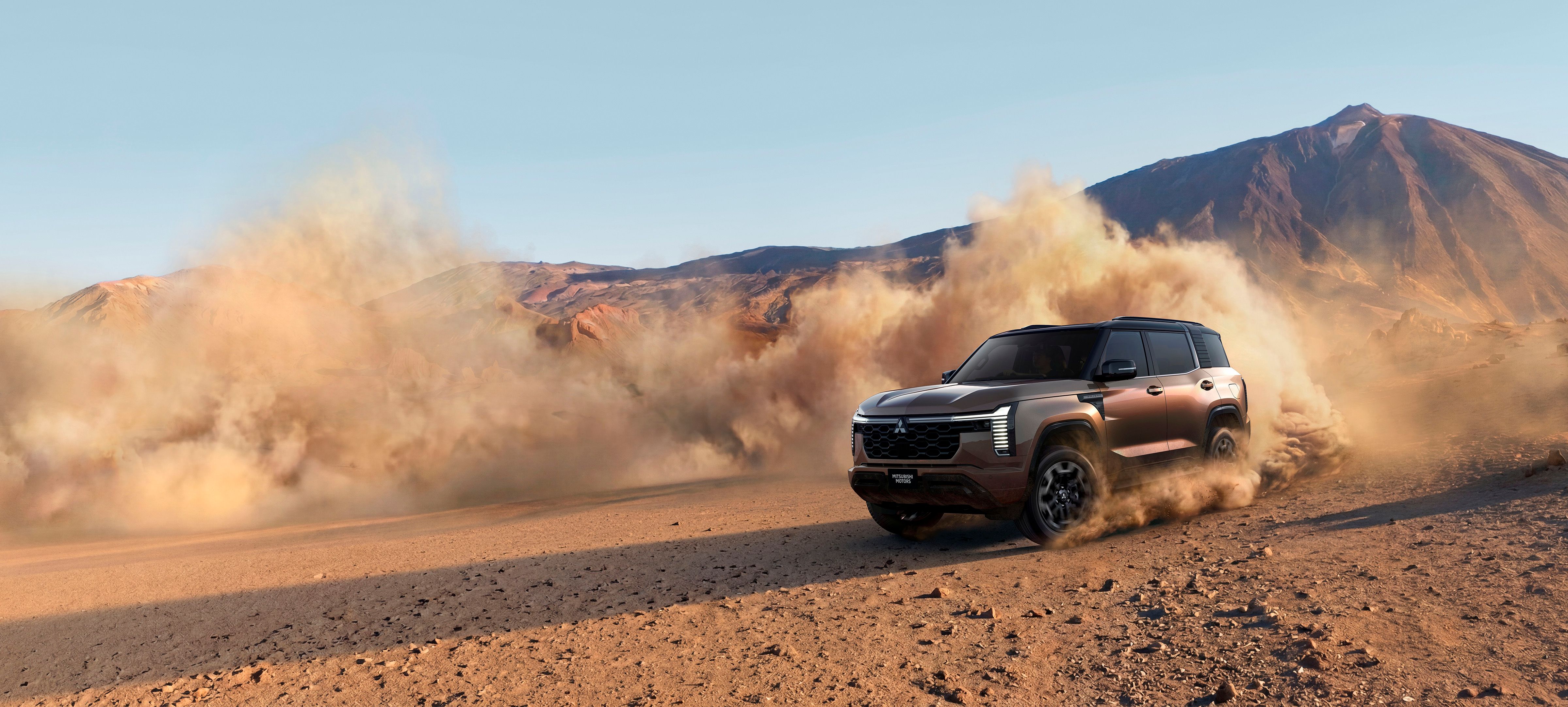 New Mitsubishi Pajero kicking up dust driving in a desert