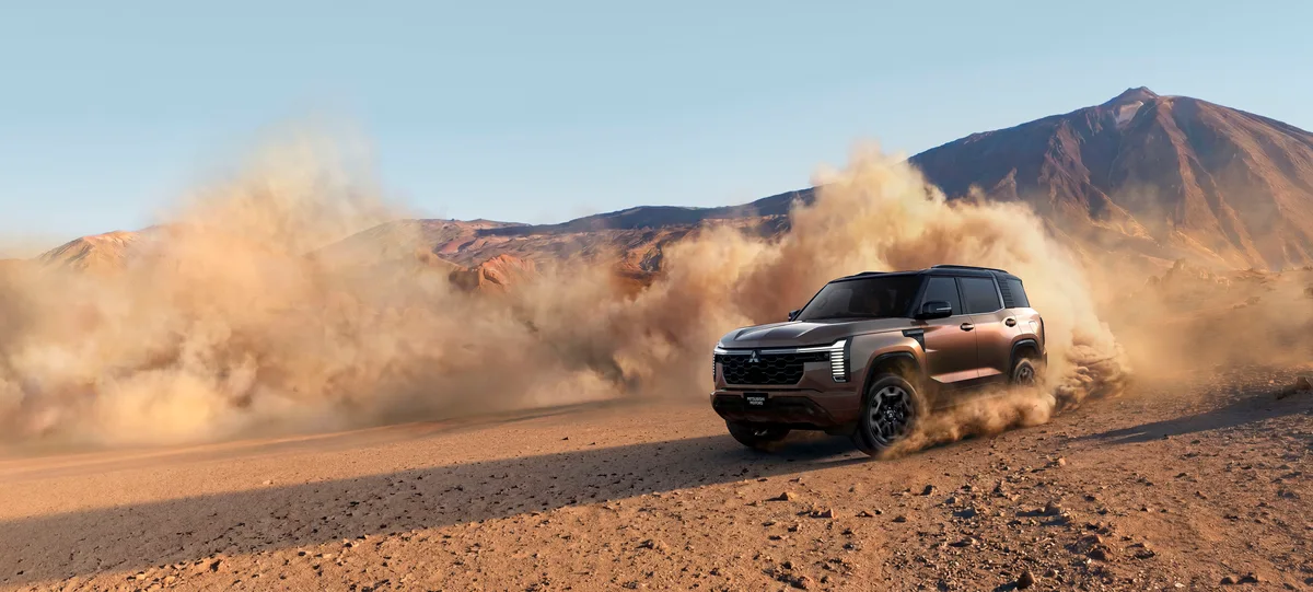 New Mitsubishi Pajero kicking up dust driving in a desert