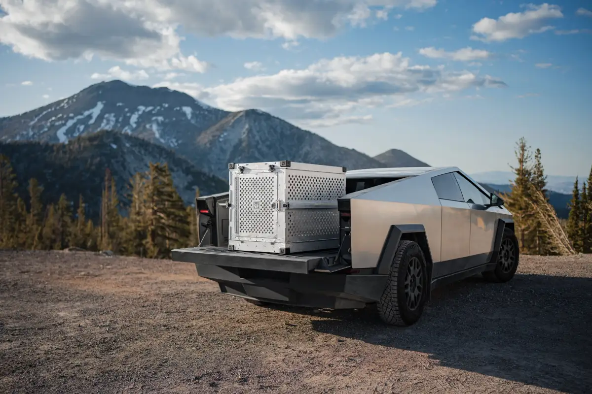 A Tesla Cybertruck with its tray open in a mountainous environment