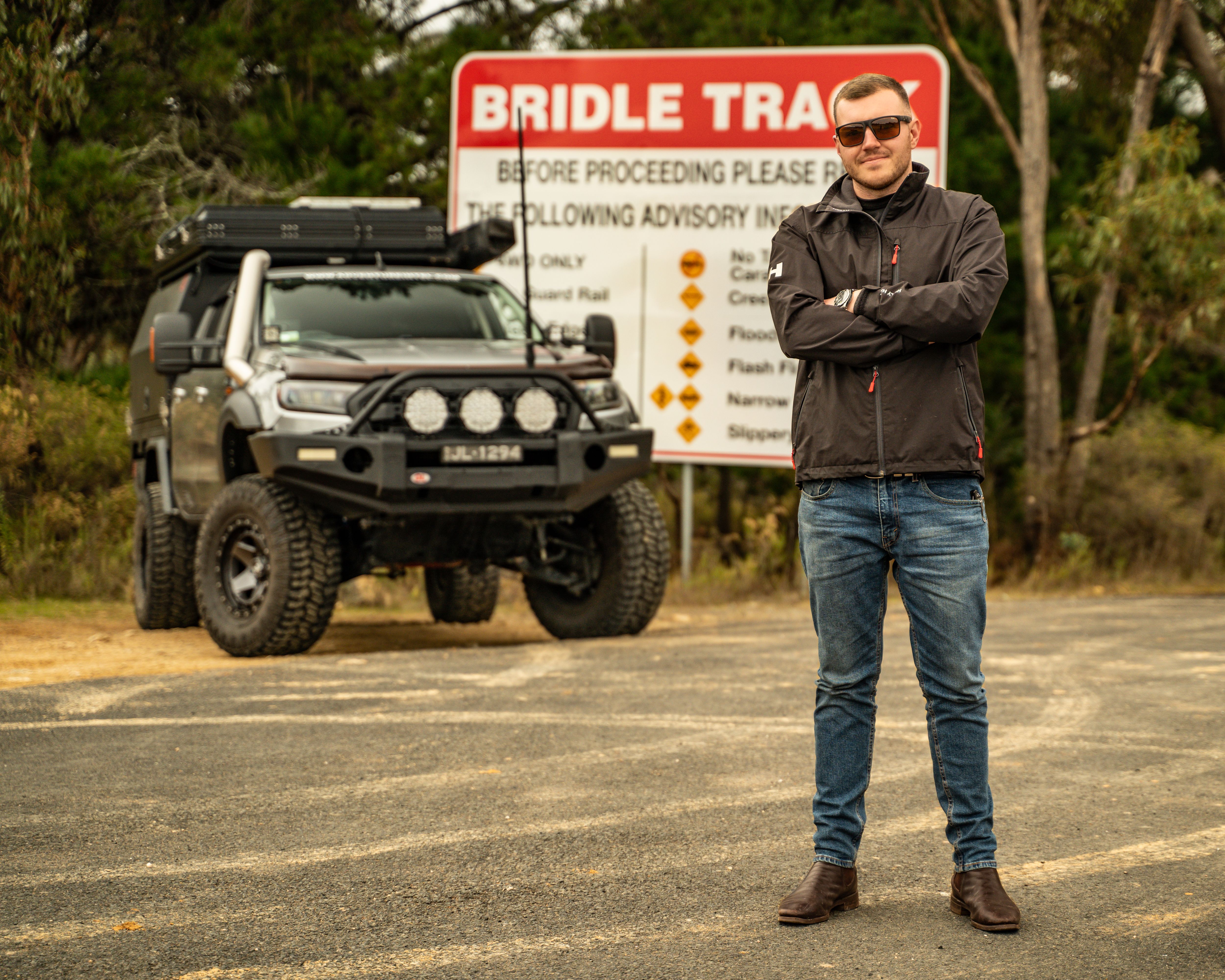 man with 4wd in front of road sign