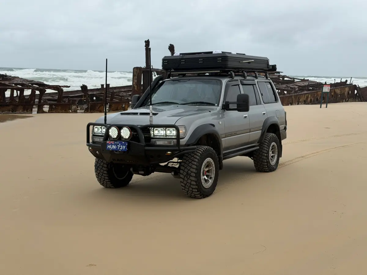 Toyota LandCruiser 80 Series on K'Gari, in front of a shipwreck