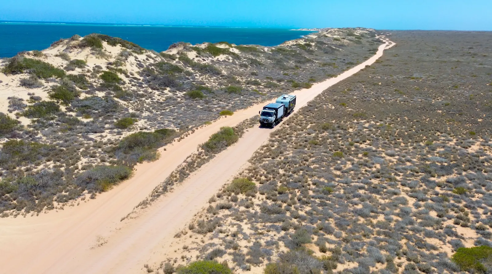 4x4 towing caravan along a coastline