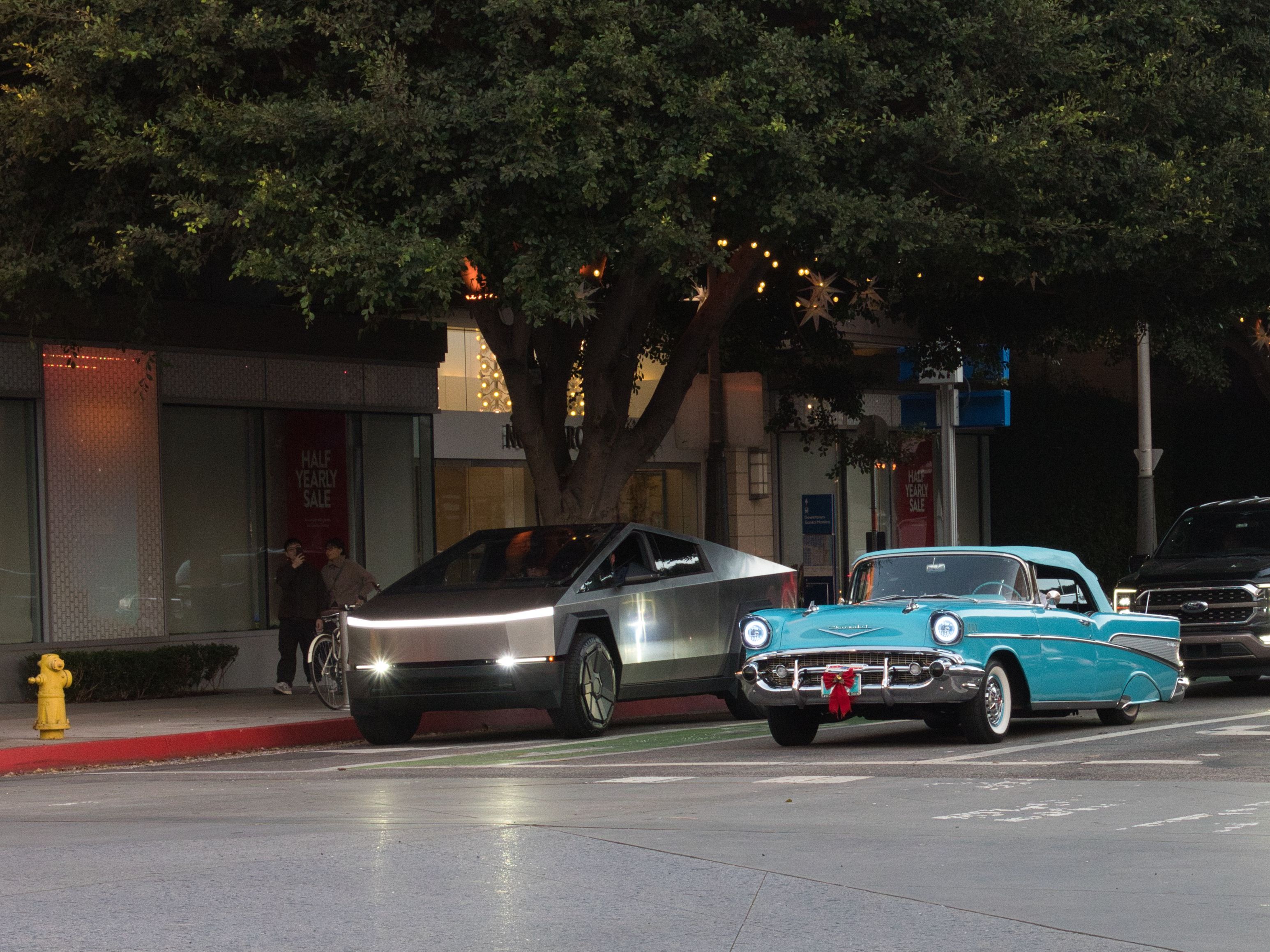 A Tesla Cybertruck next to a classic car