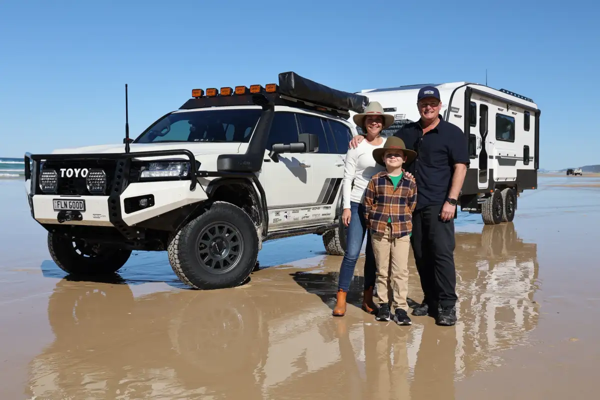 family standing in front of 4wd on beach