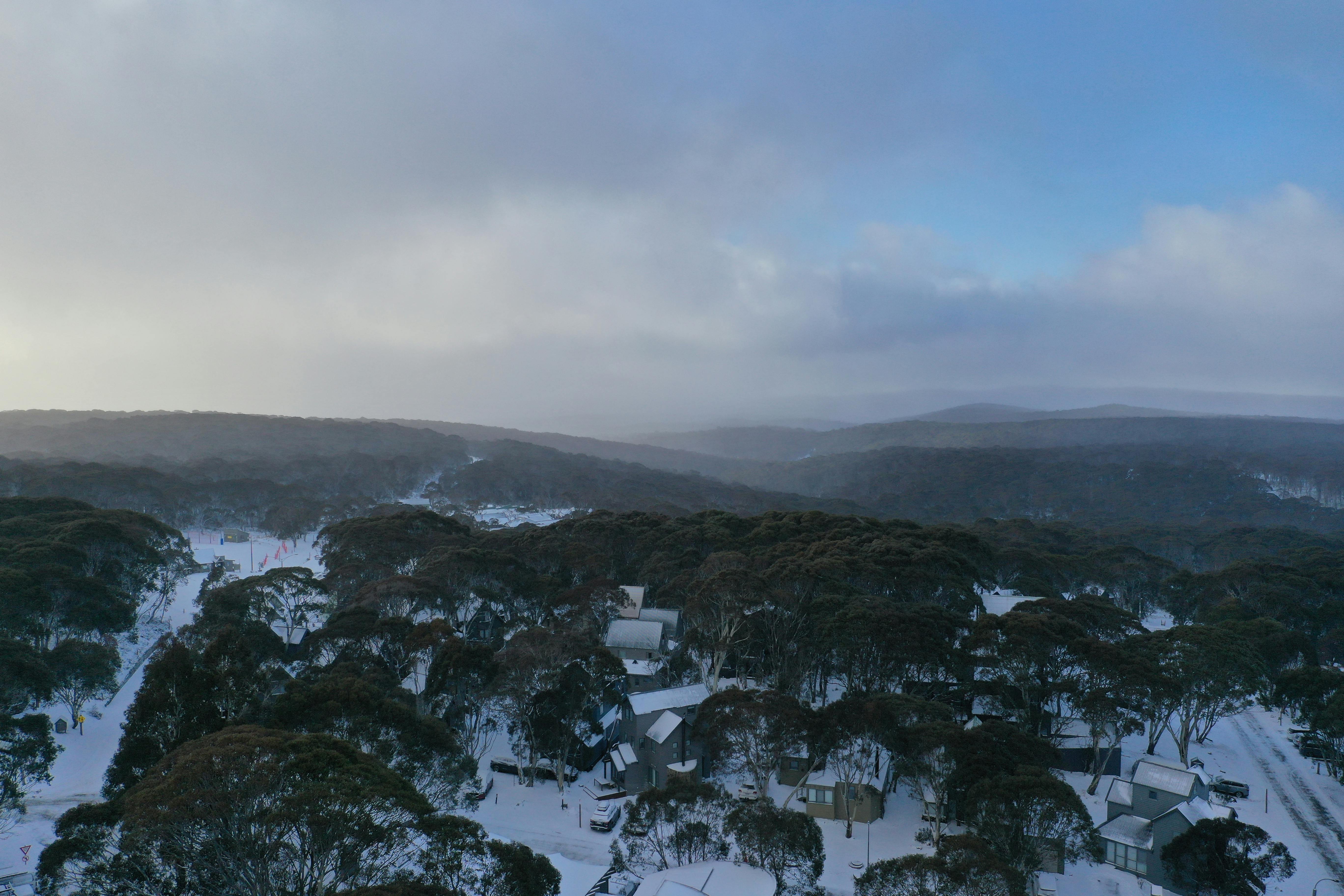 Aerial View of Trees and Houses on a Snowy Hill in Hotham Heights, VIC, Australia