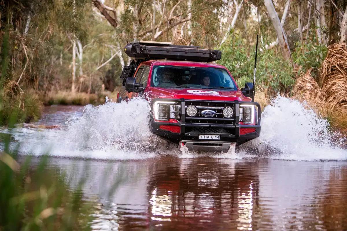 Ford 4x4 driving through water in outback australia